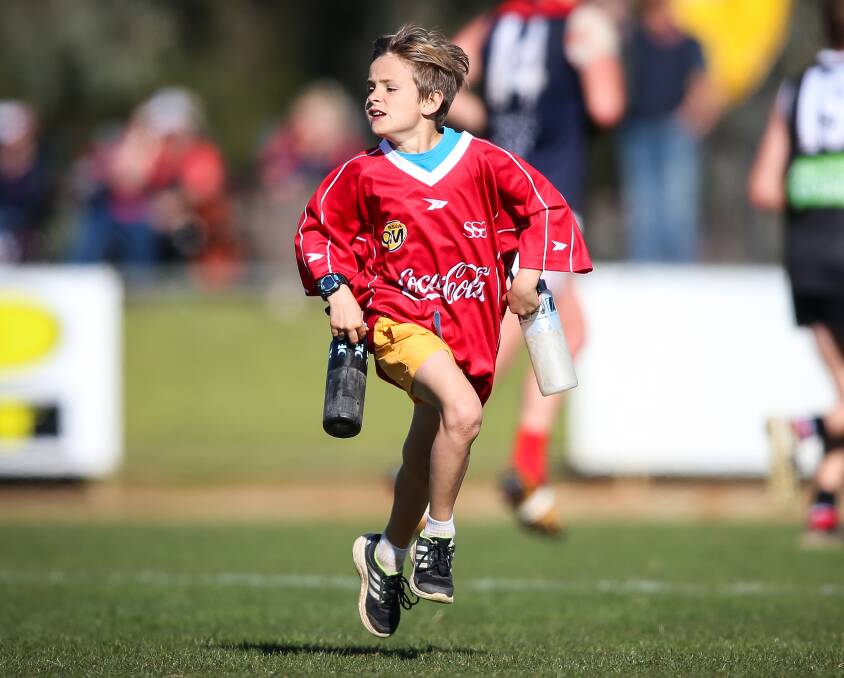 HARD WORK IN THE SUN: Jesse Cannell, 9, had the important task of running water for Wodonga Raiders senior footballers during O and M quarter finals at Wangaratta on Sunday. Picture: JAMES WILTSHIRE