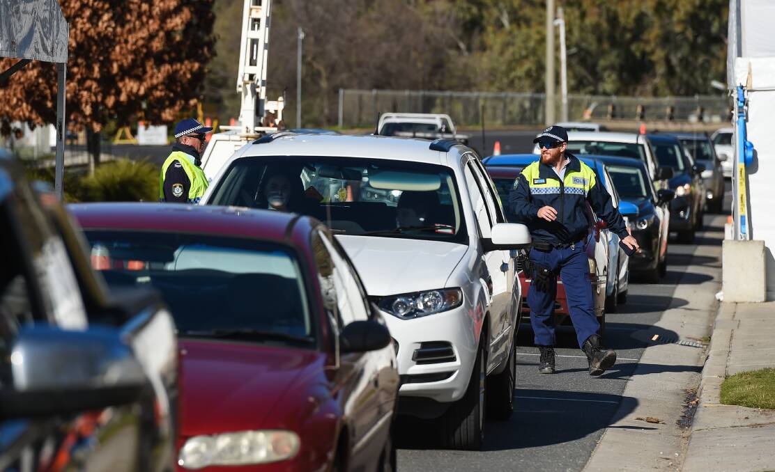 STILL LINING UP: NSW police officers at the border checkpoint at Albury on Friday, which is the subject on ongoing discussions between the premiers. Picture: MARK JESSER