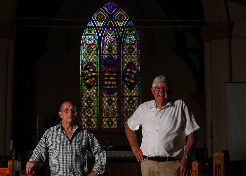 RESTORED: Hilton Newitt and Reverend Rex Everett in front of the stained glass window at St John's Anglican Church. Picture: JAMES WILTSHIRE