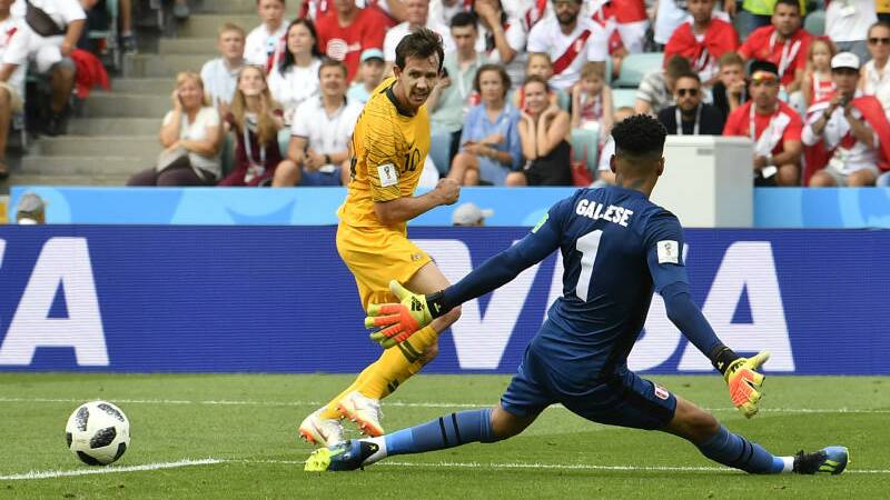 Australia's Robbie Kruse, left, plays a cross past Peru goalkeeper Pedro Gallese during the group C match between Australia and Peru. Photo: AAP