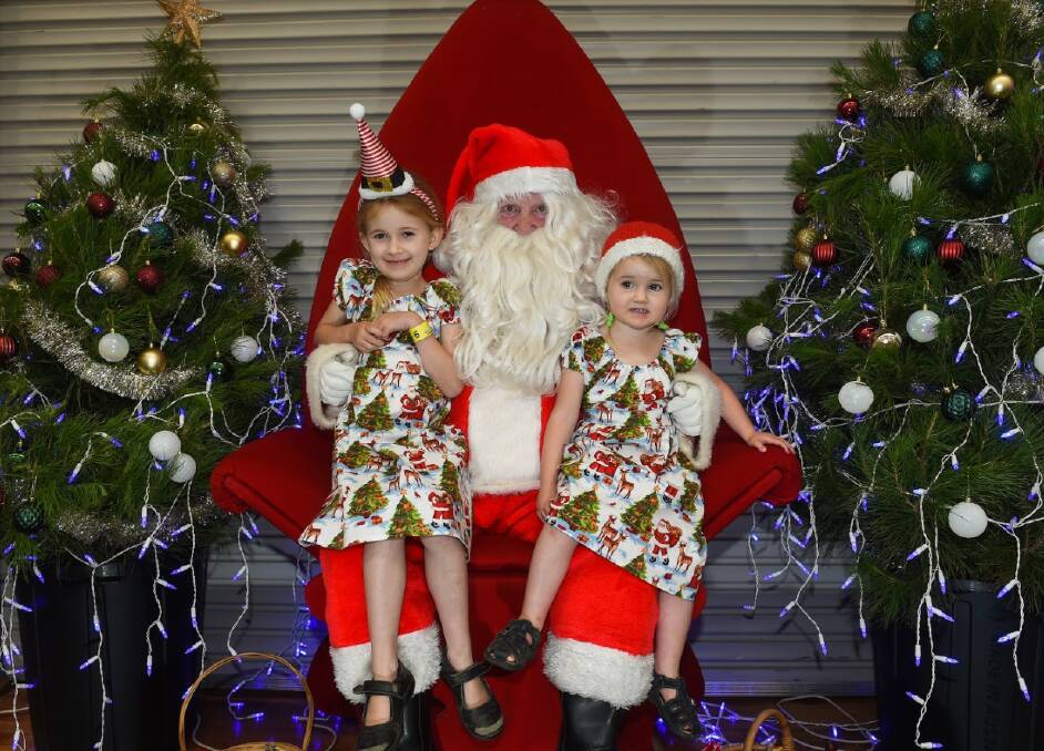 SAY CHEESE: Wodonga's Hailey and Bronte Caunt pictured with Santa at the Special Children's Christmas Party at the Wodonga Sports and Leisure Centre in 2019. Santa photos may look a bit different this year in the midst of the pandemic.