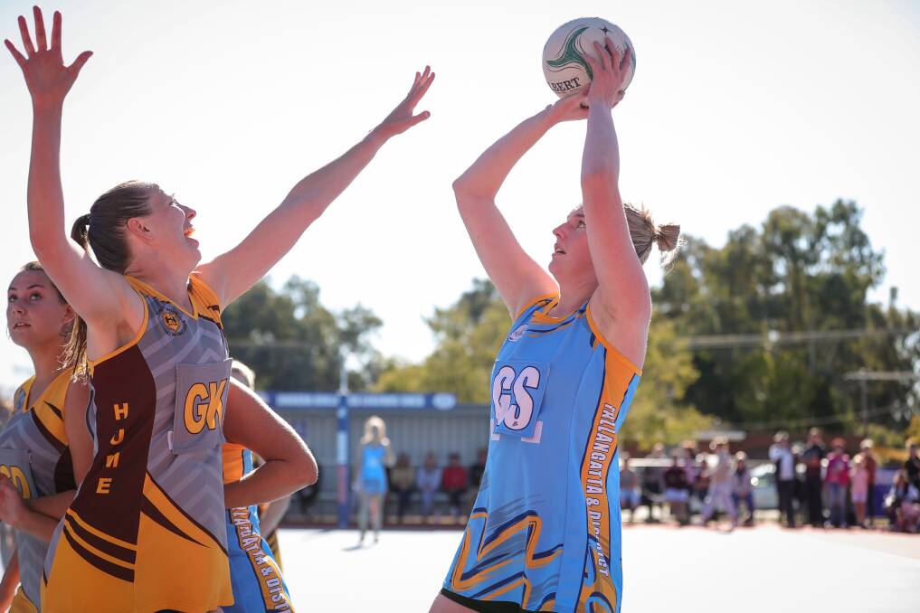 EYES ON THE PRIZE: Tallangatta and District Netball Association's Jess Barton lines up her shot under the defensive pressure of Hume League's Samantha Way during an interleague clash at Jindera on Sunday