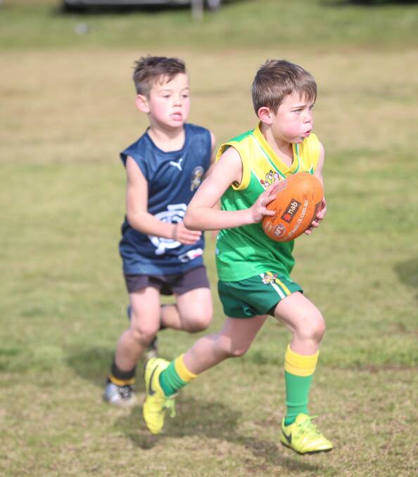 YOUNG RISING STARS: Holbrook's Ned Dodds makes his way down the football field with Albury's Charlie Packer hot on his heels during the Rand Public School's Football and Netball Development Round Robin. Picture: JAMES WILTSHIRE