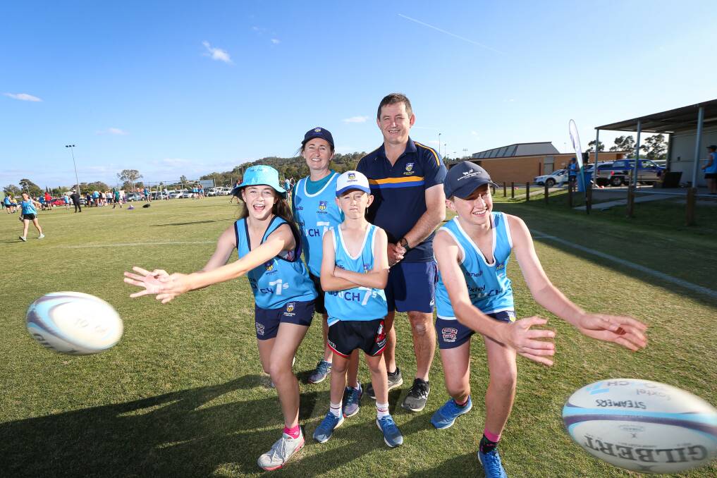 GAME ON: Nat and Dan Hogg with three of their four kids Audrey, Hugh and Will (Hattie not pictured) enjoying some fun in the sun for the Steamers' rugby touch sevens competition. Picture: JAMES WILTSHIRE.