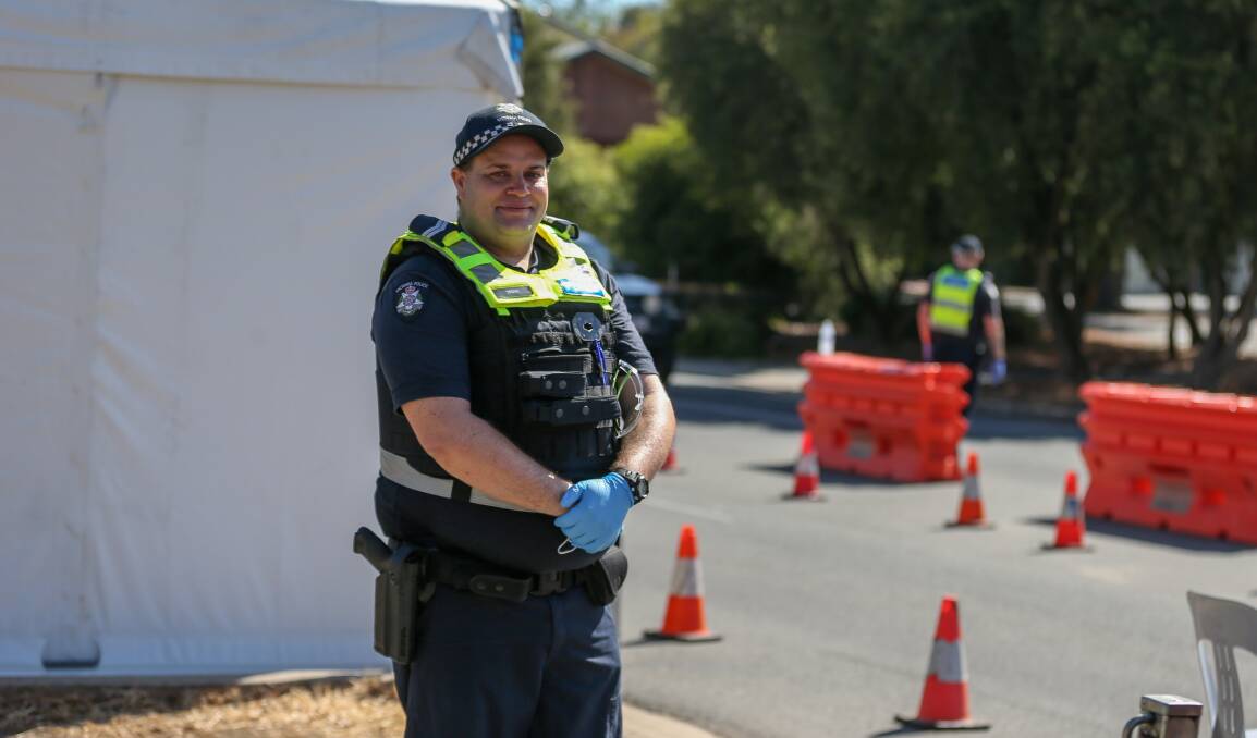 THANK YOU: Senior Constable Timothy Howell from Melbourne manning the checkpoint at the Lincoln Causeway in Wodonga on Christmas Day.