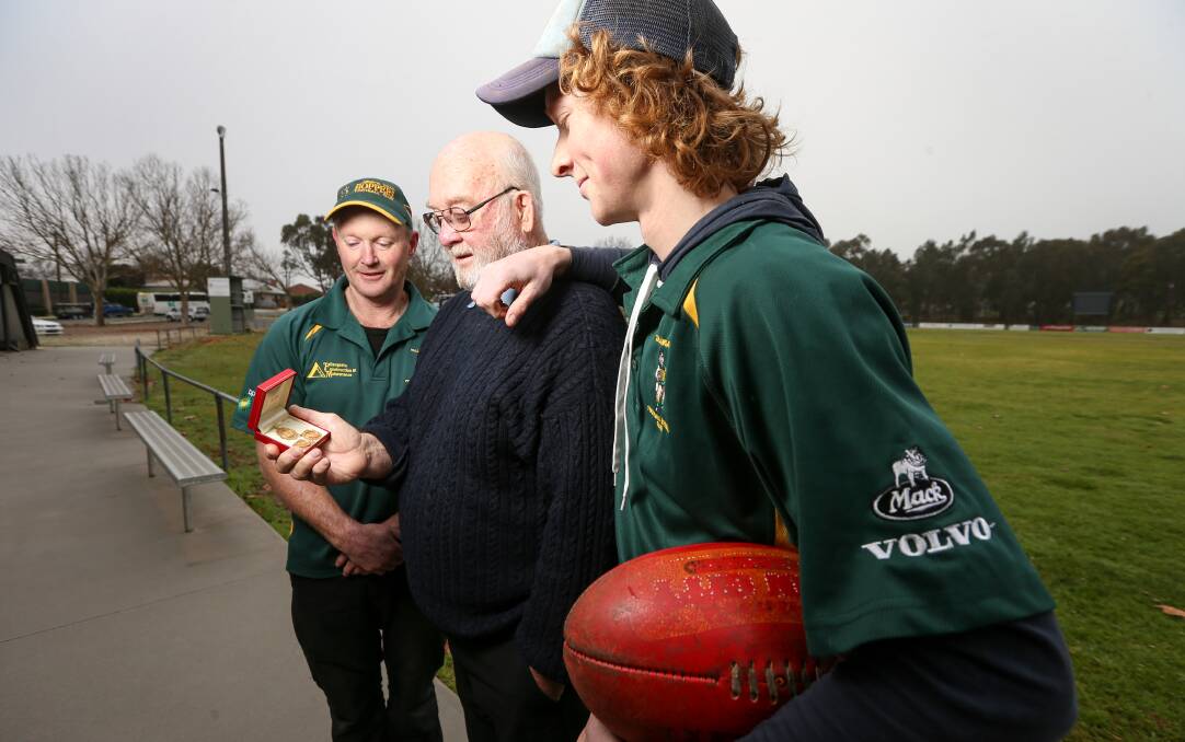 FAMILY TREE: John Maddock shows medals won by his father to his son, John, and grandson, Jake, at Rowan Park in Tallangatta where the three generations have grown up playing football for the Hoppers. Picture: JAMES WILTSHIRE