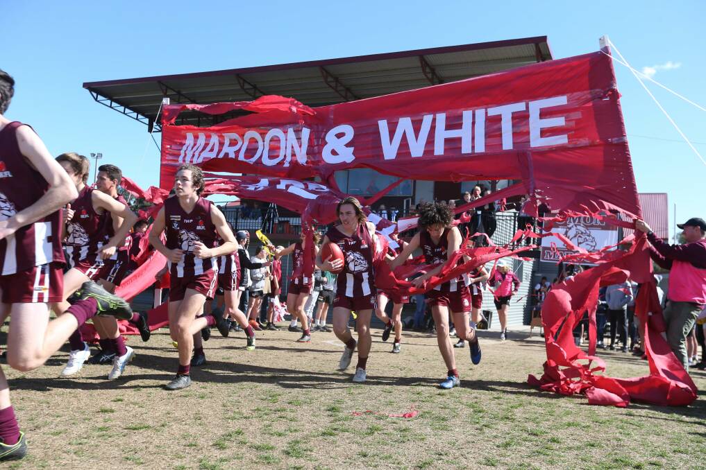 PUMPED: Wodonga Maroon run through their banner at Martin Park before taking on Albury in the under-16's decider.
