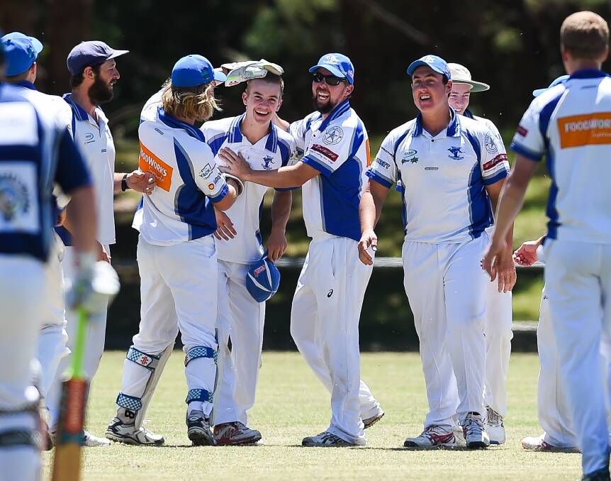 CELEBRATIONS: Yackandandah congratulates teammate Harry Cox for his assistance in helping with a wicket during the side's win on Saturday.