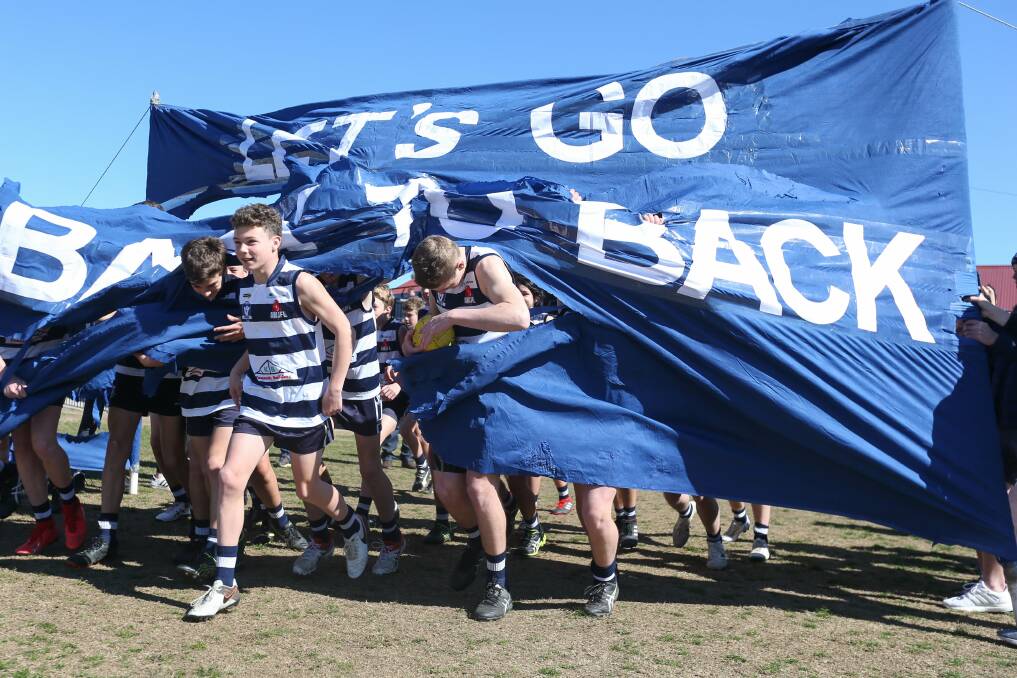 READY TO GO: Yarrawonga's under-14's running through their banner at Martin park on Sunday as they take to the field for the grand final.
