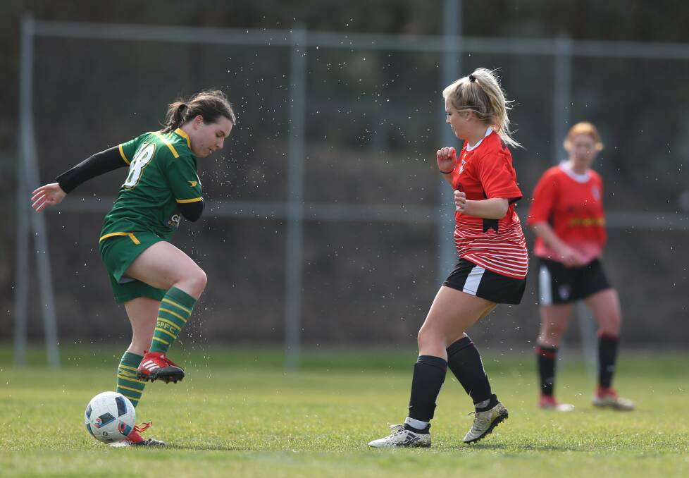 SLIP AND SLIDE: St Pats' Maggie Duck and Boomers' Sarsha Smith in the slippery conditions during Sunday's clash. Picture: TARA TREWHELLA.