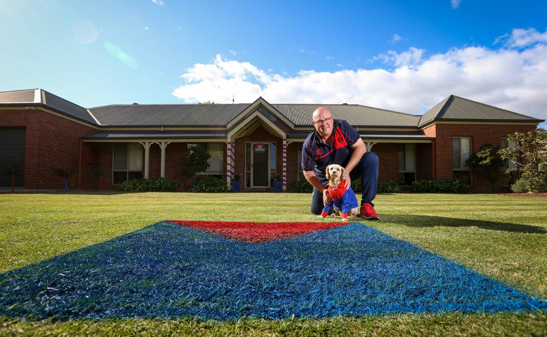 HEART BEATS TRUE FOR THE RED AND THE BLUE: Devoted Melbourne supporter Heath Naughton and his dog Angel weren't hiding their colours for the AFL Grand Final at their East Albury home on Saturday. Picture: JAMES WILTSHIRE