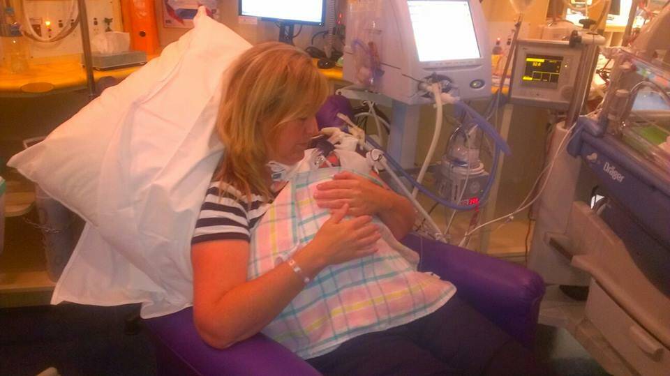 A MOTHER'S TOUCH: Border Mail journalist Jodie O'Sullivan (top) gets a moment to hold her tiny daughter in the critical care unit at Melbourne two days after she was born.