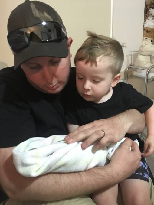 PRECIOUS MOMENT: Joshua Smith and his son Caleb, 3, tenderly hold a forever sleeping Georgia. Picture: SUPPLIED 