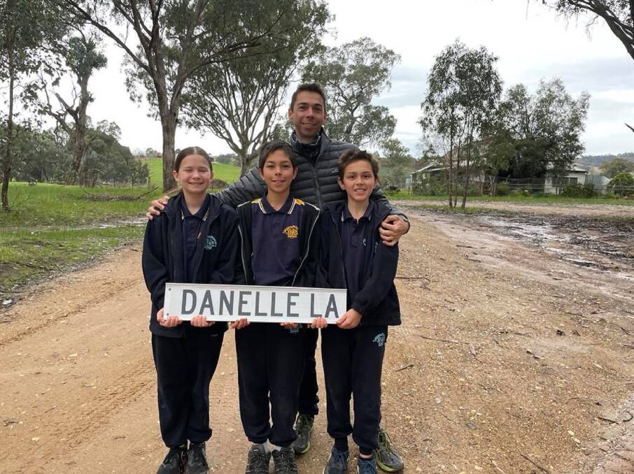 LASTING LEGACY: James Filby with Sophie Reid (who his late wife Danelle provided care for; James has now taken over that role) Ari Filby, 12, and Lawson Filby, 11, with the street sign to their home named after a loving mother and wife. Picture: SUPPLIED