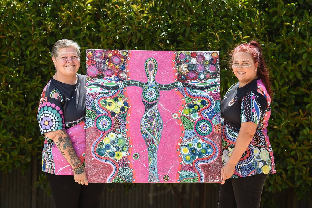 VIBRANT: Kim Saunders (cultural safely adviser for family violence) and Bec Symonds (family violence support worker) hold artwork by Tamara Murray. Picture: MARK JESSER