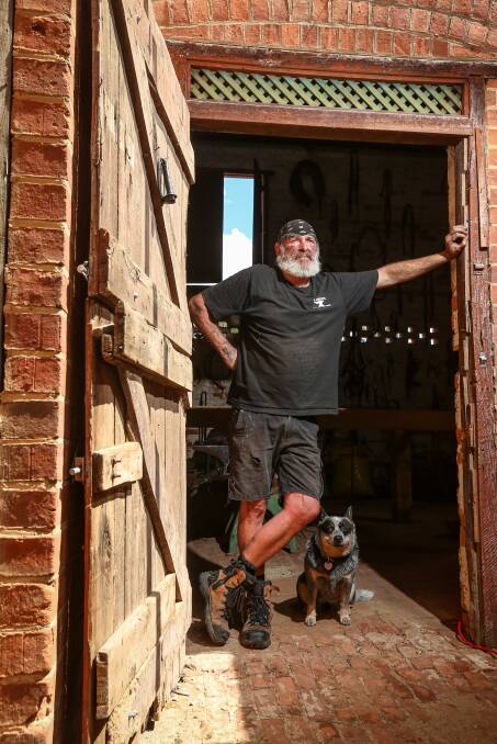 IF THESE WALLS COULD TALK: Blacksmith Brendan Thompson (with his dog Roxy) is fascinated by the historic buildings off Rutherglen's Main Street. Pictures: JAMES WILTSHIRE
