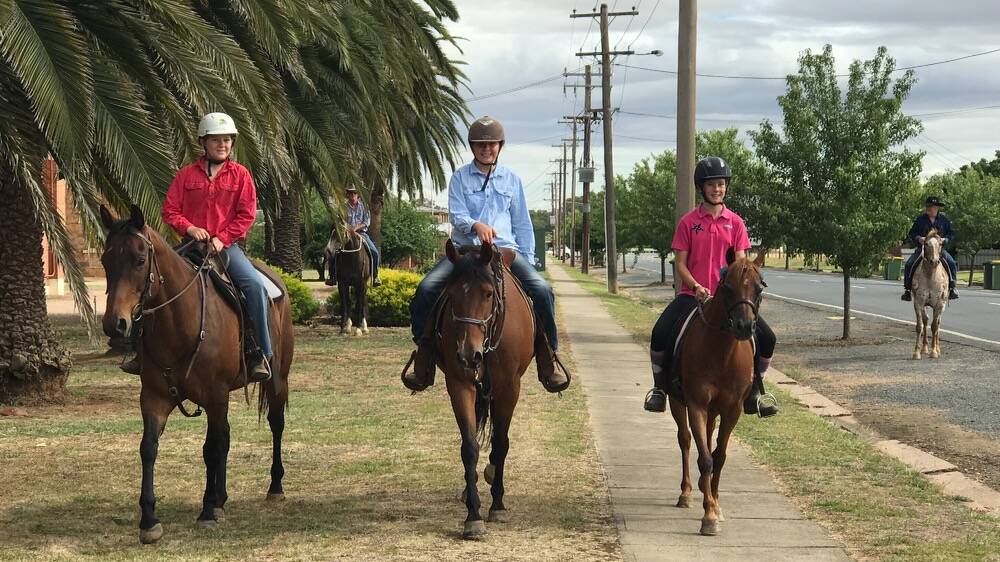 WHAT A RIDE: Emily Phegan, Larissa Schilg and Evie Torrens (with Danny and Warwick Phegan accompanying them) ride along the streets of Walla for their last day of primary school together.
