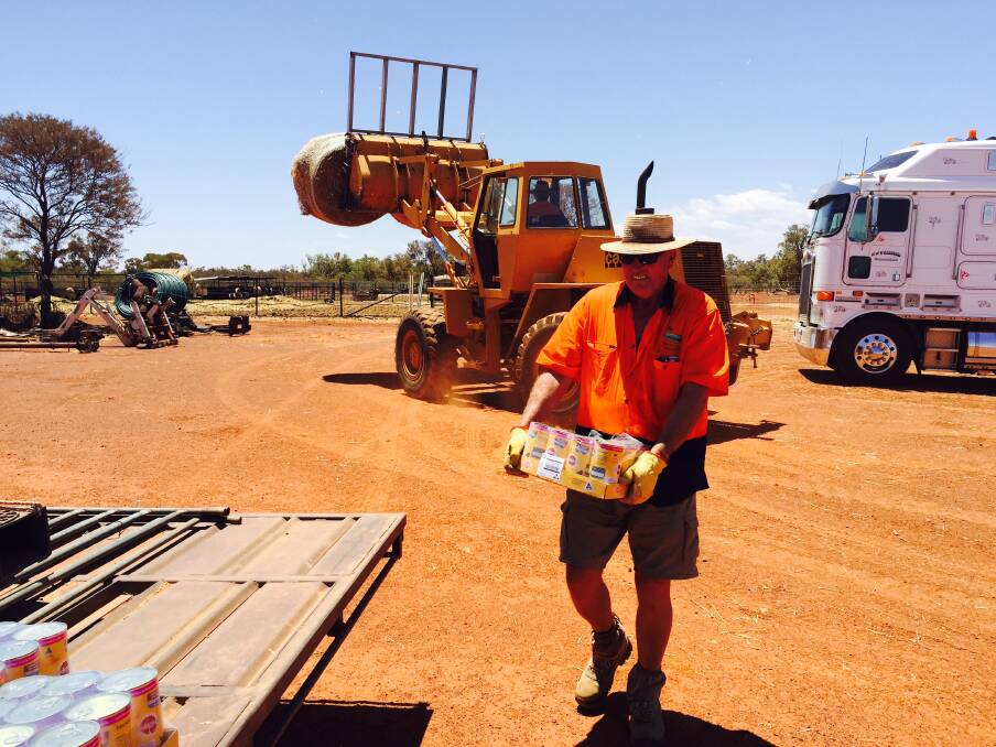 TOP TUCKER: FIrst-time hay runner Jim Parrett, from Jindera, unloads dog food donated by Mars Petcare Wodonga. Farmer Shane Warner says the canned food will be a "real treat" for his working dogs.