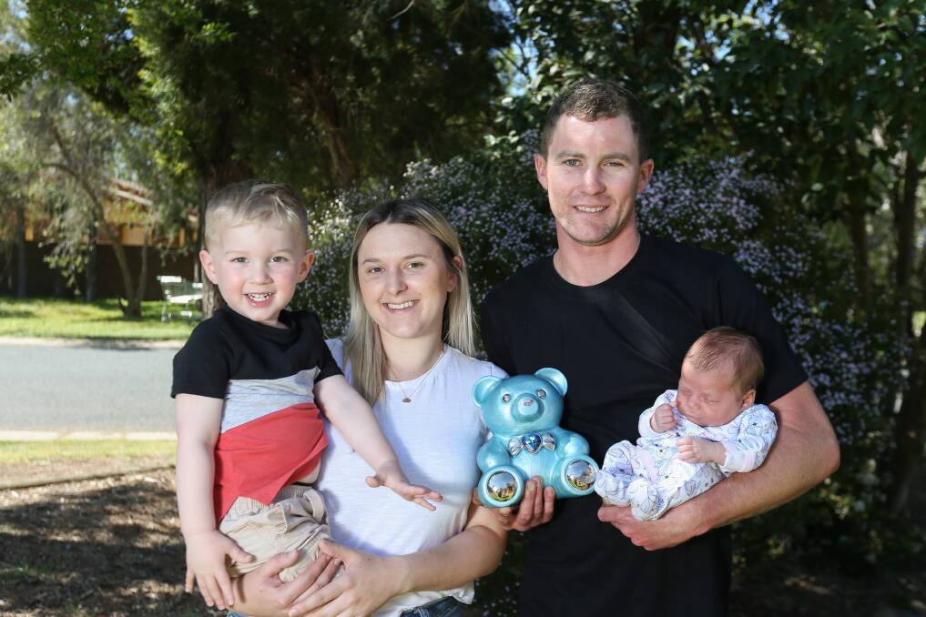 'PERFECTLY IMPERFECT': Jessee Williams, 28, and Liam Butson, 29, with Noah, 2, and Maia, 5 weeks, and the teddy bear urn that holds baby Finn's ashes. Pictures: TARA TREWHELLA