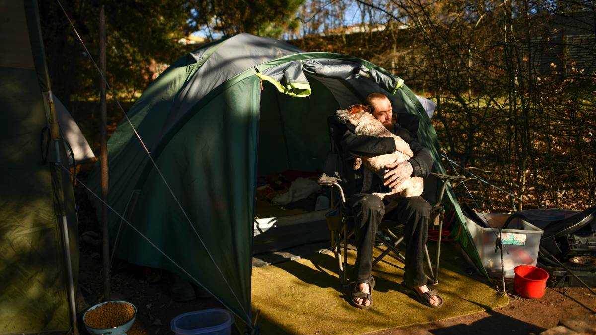 Jonathan 'Budgie' Williams with one of his two staffy dogs outside his family's tent home at Mt Pleasant in Tasmania's North. Picture: Scott Gelston