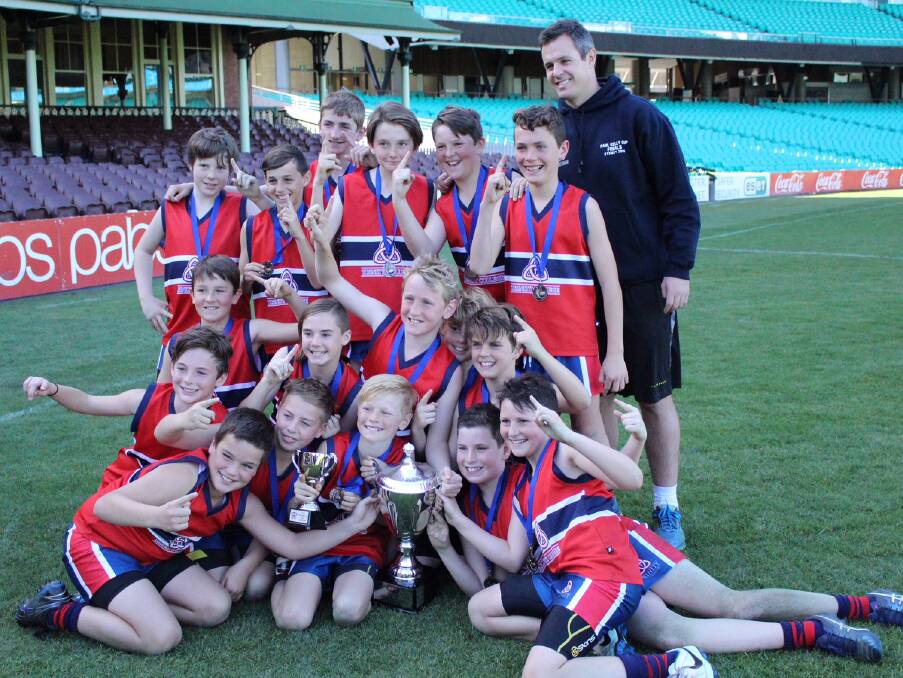 Trinity Anglican College players celebrate their win with coach Jarrod Hillary at the SCG.