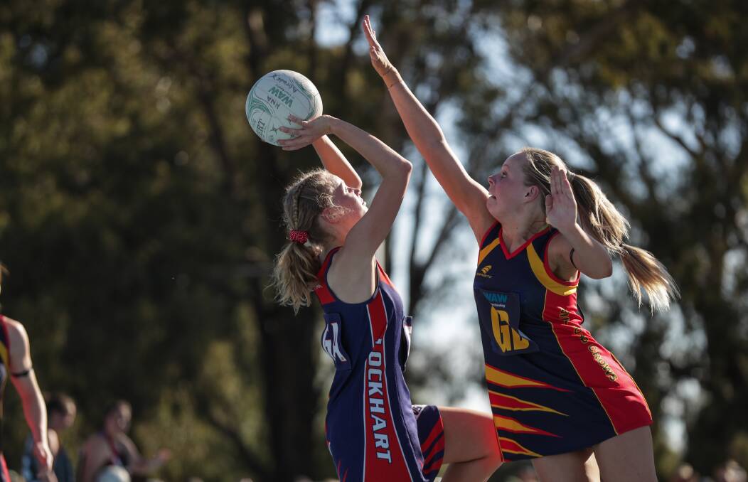 Lockhart youngster Ruby Bouffler shoots for goal while under pressure from Crow Brooke Morley in last year's premiership decider at Walbundrie.
