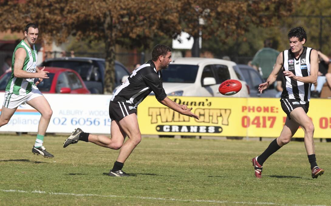 ON A STRING: Murray Magpie Josh Senior fires out a handball to teammate Trent Logue at Urana Road Oval on Saturday. Picture: ELENOR TEDENBORG