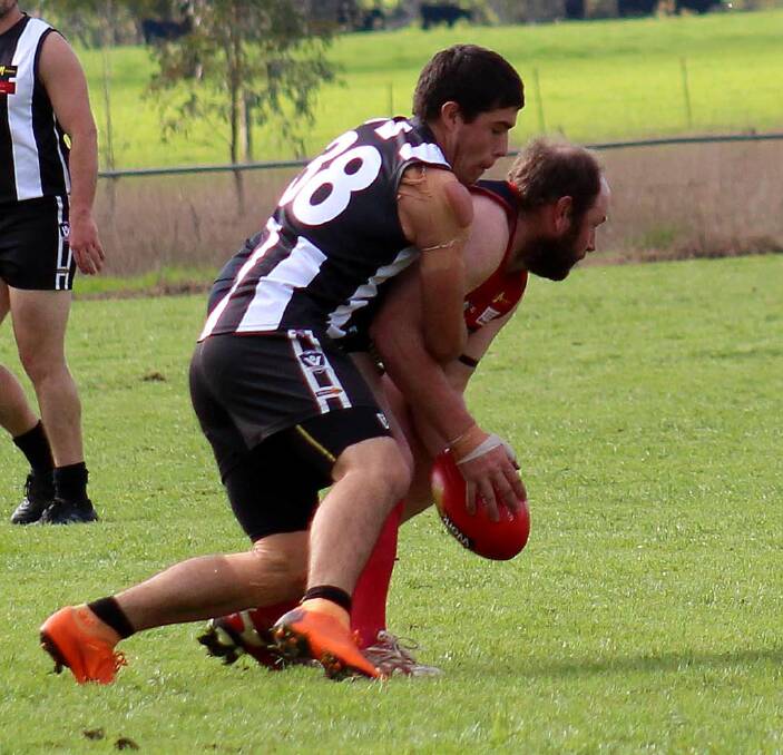 Corryong coach Evan Nicholas is pinned in a tackle by a Border-Walwa opponent. Nicholas believes changes must be made for the competition to continue.