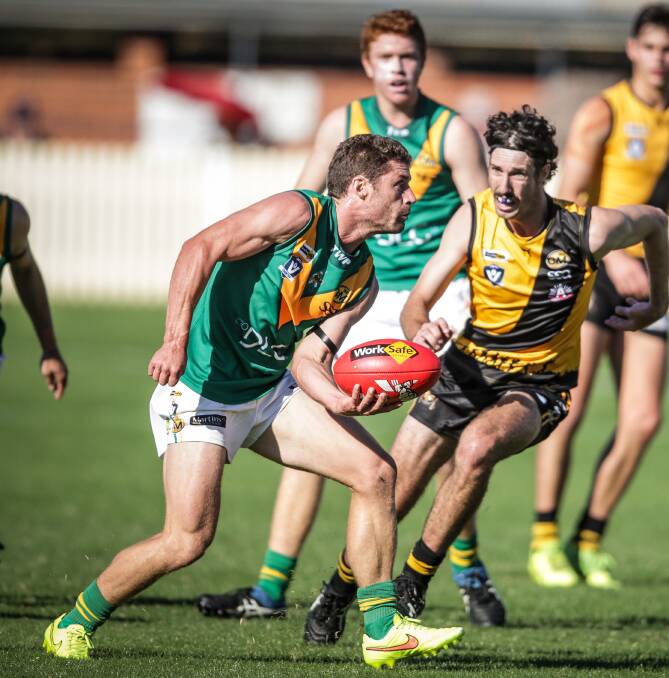 North Albury skipper David Miles fires off a handball before young Tiger Jessy Wilson pounces at Albury Sportsground. Picture: JAMES WILTSHIRE