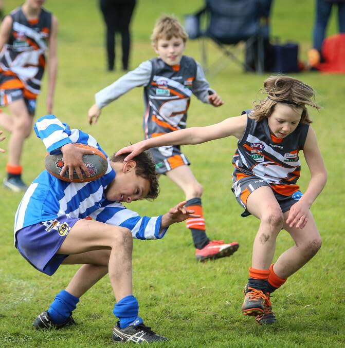 DUCKING FOR COVER: Corowa's Archer Coppolino evades a tackle from Giant Alex Collier in the under-8 competition during the Rand Junior Football Netball Carnival on Sunday. Picture: JAMES WILTSHIRE