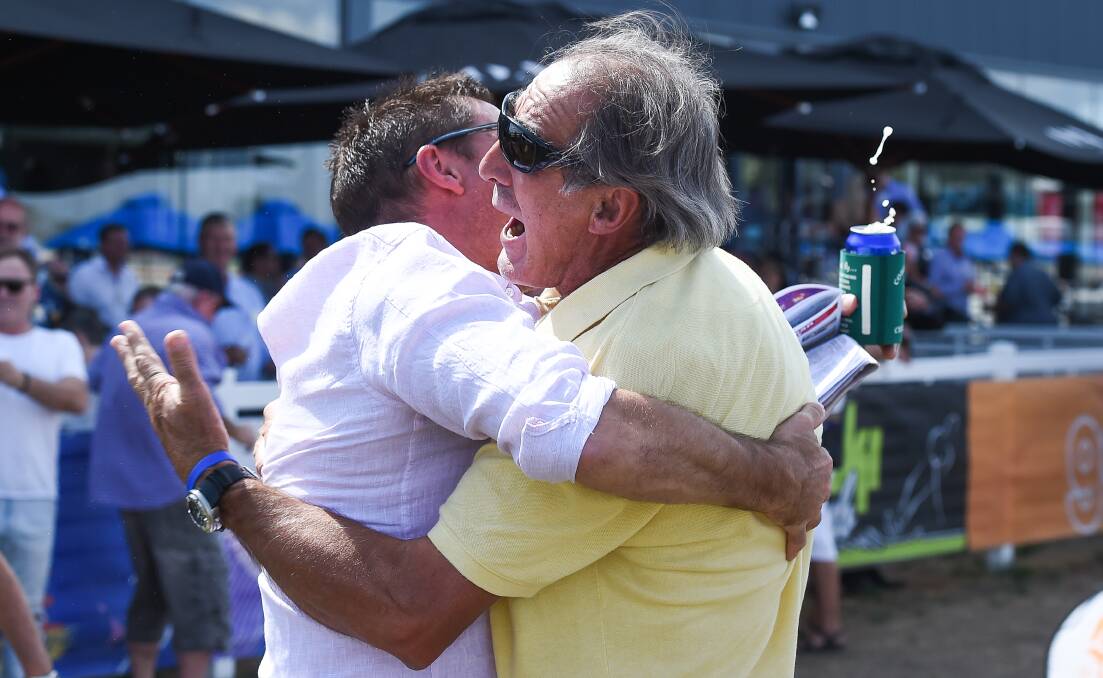 Part-owner and former Carlton premiership player Val Perovic (right) celebrates Silent Warrior's victory.