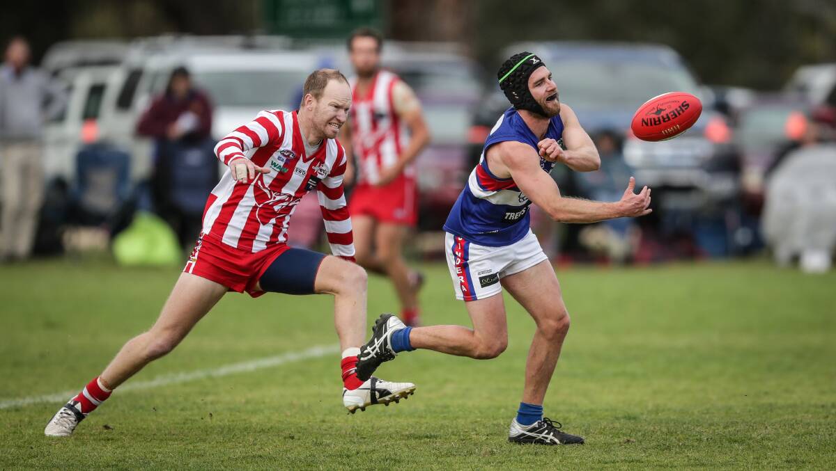 Henty coach Joel Price gives chase to Jindera's Jesse Wellington during last season's finals at Walbundrie.
