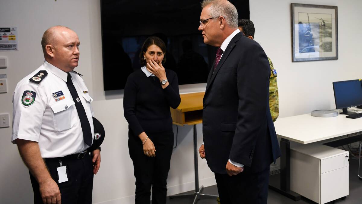 Prime Minister Scott Morrison speaks to RFS Commissioner Shane Fitzsimmons during a visit to HMAS Albatross in Nowra on Sunday. Picture: AAP 