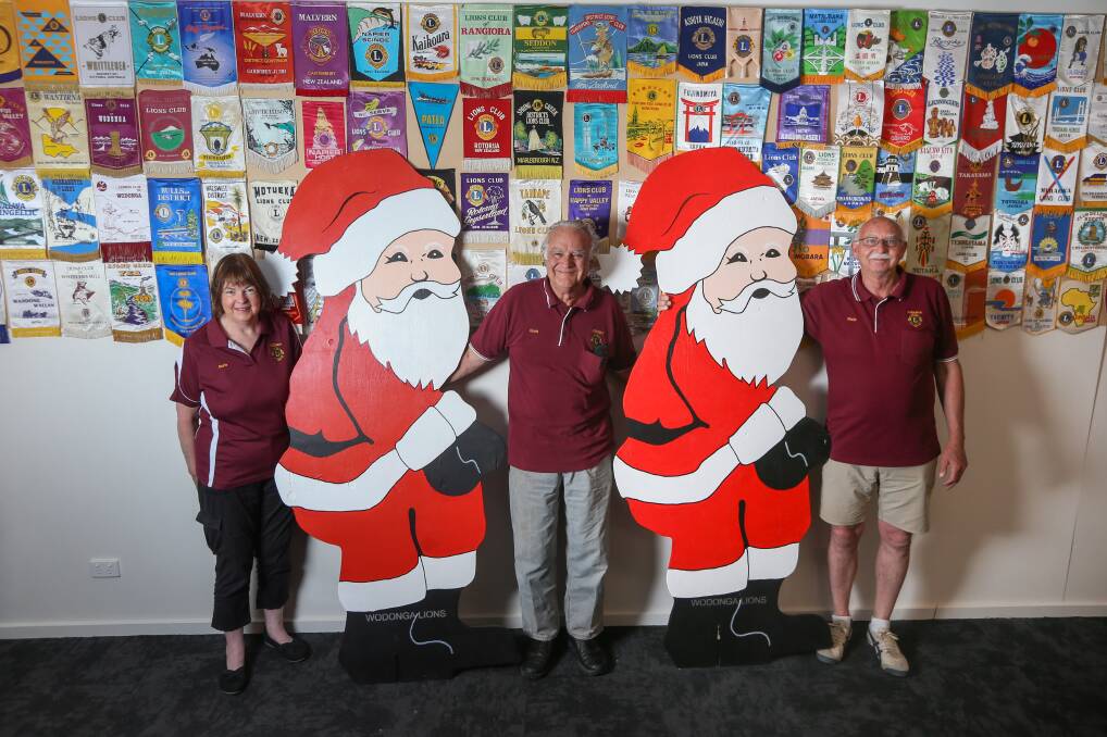 Imposing figures: Wodonga Lions Club members Marie Furze, David Burr and Martin Melzer with some of the giant Santas, measuring 2.1 metres high, that are being sold for charity. Picture: TARA TREWHELLA