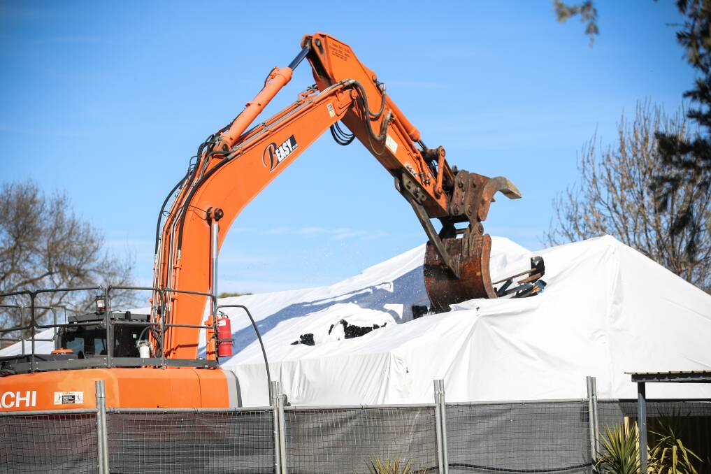 Grim sight: An asbestos-filled house in Holbrook is demolished. A Wodonga home faces the same fate but there is no government scheme to assist the owners.
