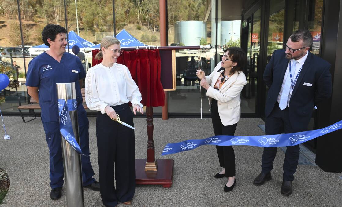 Albury Wodonga Health director of nursing (emergency and critical care) Clare Maher cuts a ribbon as Victorian Health Minister Mary-Anne Thomas unveils a plaque at the opening of the new emergency department. Picture by Mark Jesser 