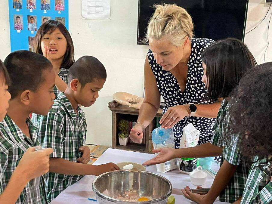 Taste for reaching: Anna Speedie assists students in a kitchen at the Thai school in Phrae which is more than 500 kilometres north of Bangkok. She also imparted some Australian cultural cues such as the Oi, Oi, Oi chant and how to say 'g'day'.