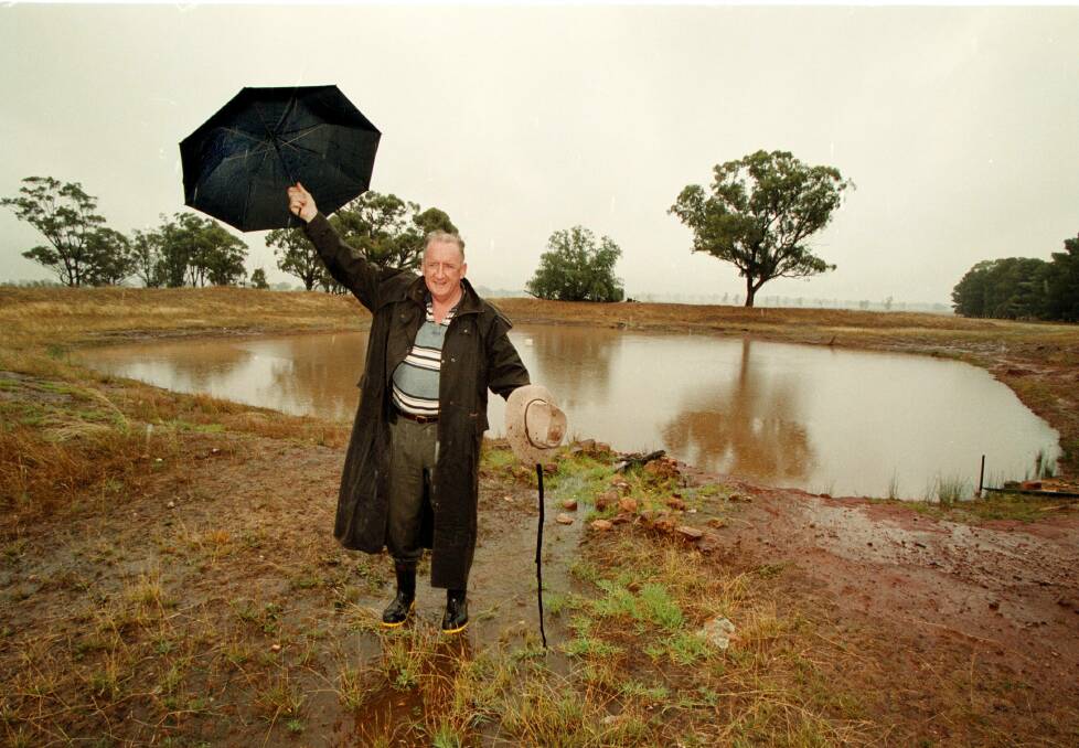 Flashback: Tim Fischer in December 1999 celebrating rainfall which helped boost the water in a dam at his Boree Creek farm. He this week called for more storages to be built.