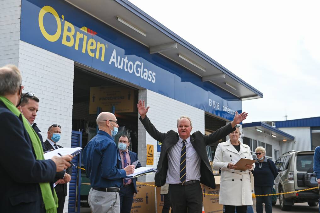 All done: Auctioneer Andrew Dixon puts his arms up to indicate he has taken the final bid and the sale face-off for the block on the corner of Young and Smollett streets in Albury is complete. Picture: MARK JESSER