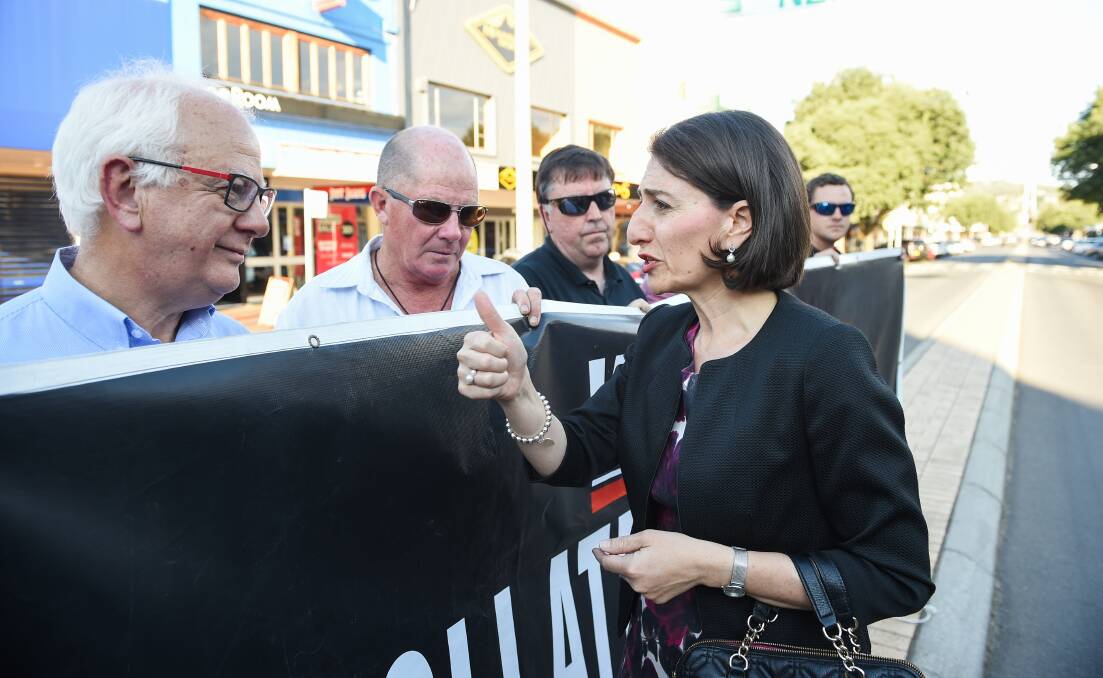 Thumbs up in the end: Bob Mathews and other supermarket owners with NSW Premier Gladys Berejiklian on the centre median strip in November during their protest over the state's container deposit scheme.