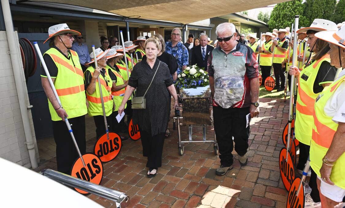 Brian Beach's coffin is escorted to the hearse in front of a guard of honour made up of his Wodonga school crossing supervisor colleagues. Picture by Mark Jesser 