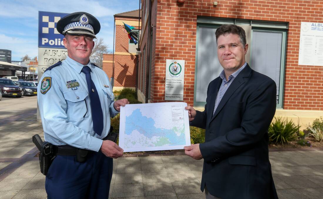 Where you can go: Murray River police district chief Superintendent Paul Smith and member for Albury Justin Clancy with the map outlining the extent of the new blue border zone either side of the state boundary. Picture: TARA TREWHELLA