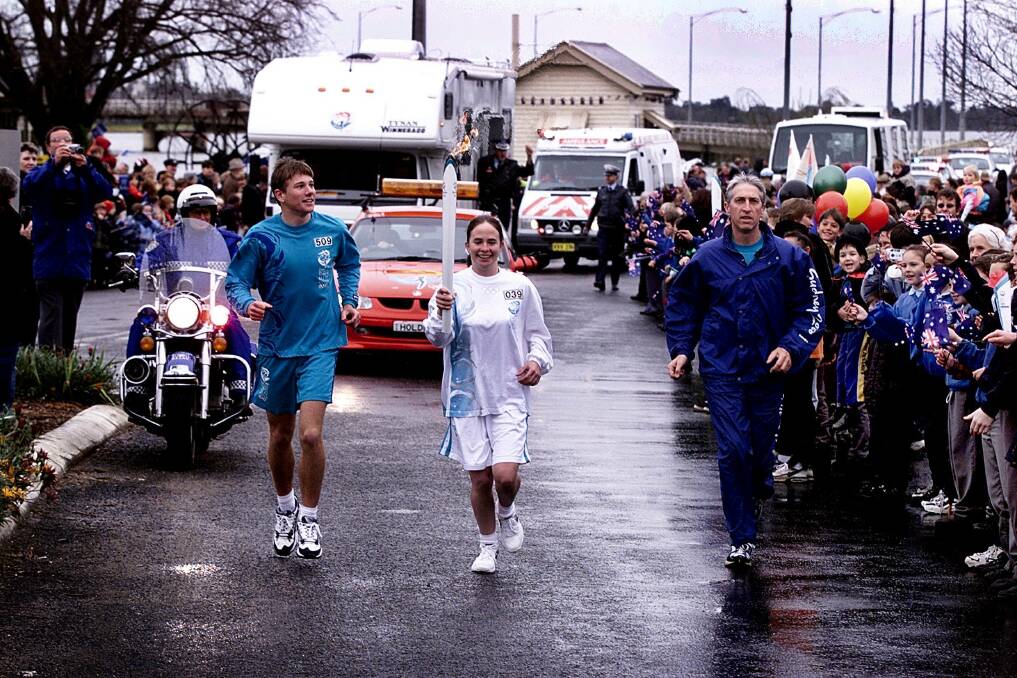 Hello again: Former Corowa High School student Sally Gorman, who was then a 19 year-old university student, carries the torch back into Victoria for a trip around Yarrawonga.