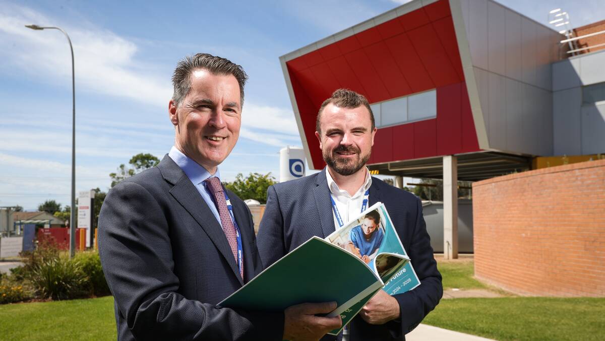 Albury Wodonga Health leaders Bill Appleby and Jonathan Green pictured with their organisation's annual report on December 18 last year, a day before their joint letter to state health ministers.