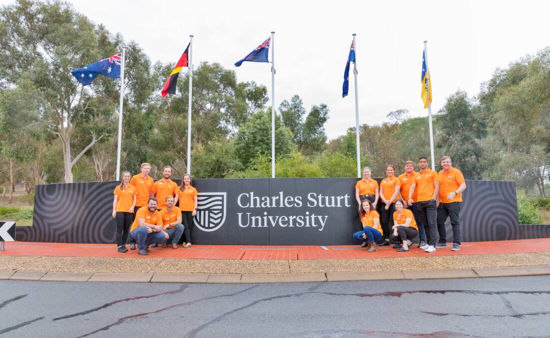 Fresh look: Students with the new logo following its unveiling at an entrance to the university's Wagga campus on Wednesday morning.