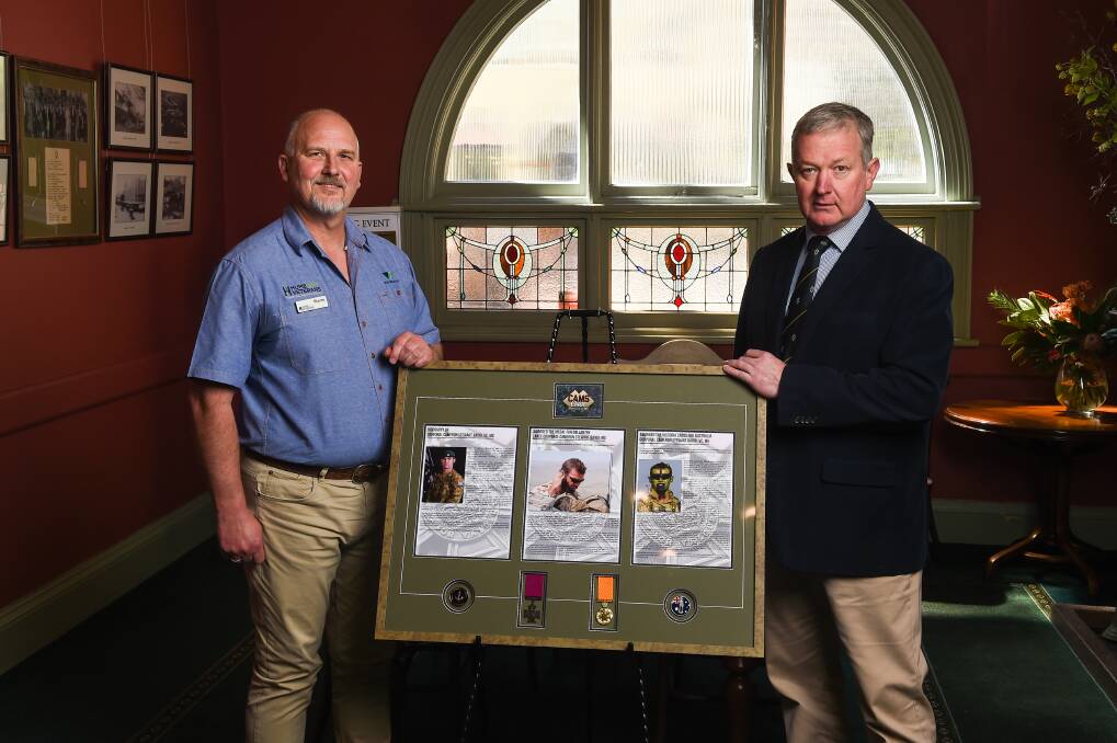 Auction item: Wayne Taylor and David Bruce with a tribute to Corporal Cameron Baird that will be sold at next month's fundraiser at the Albury Club. It includes a Victoria Cross replica medal. Picture: MARK JESSER