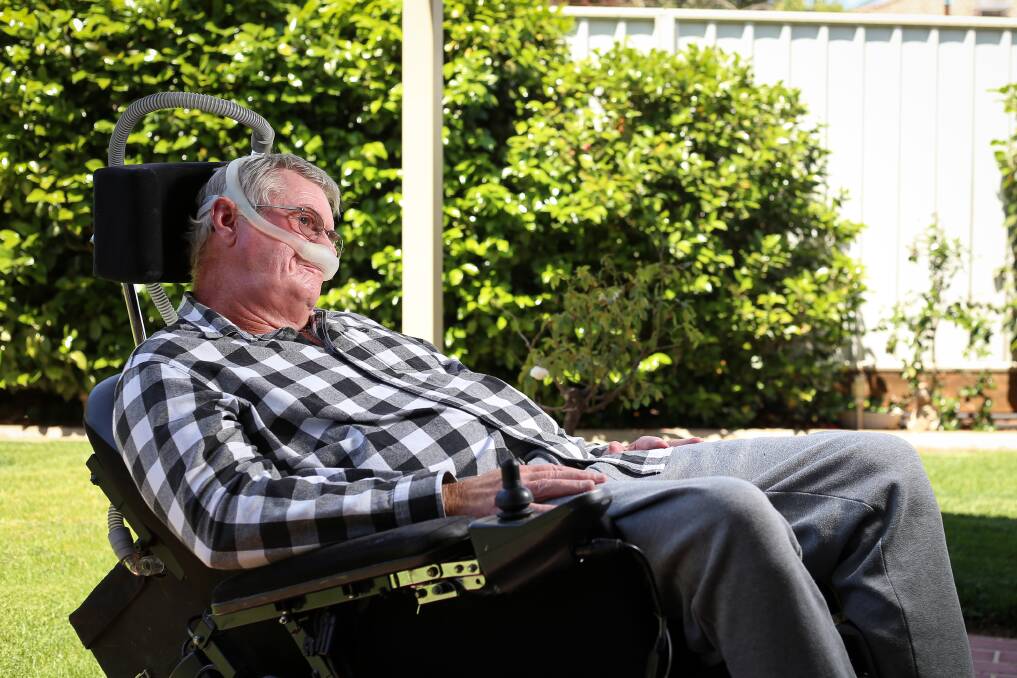 Frustrated: Graham Walker at his Lavington home in the motorised wheelchair he uses for transport. He also requires a machine to assist him to breathe properly. Picture: JAMES WILTSHIRE
