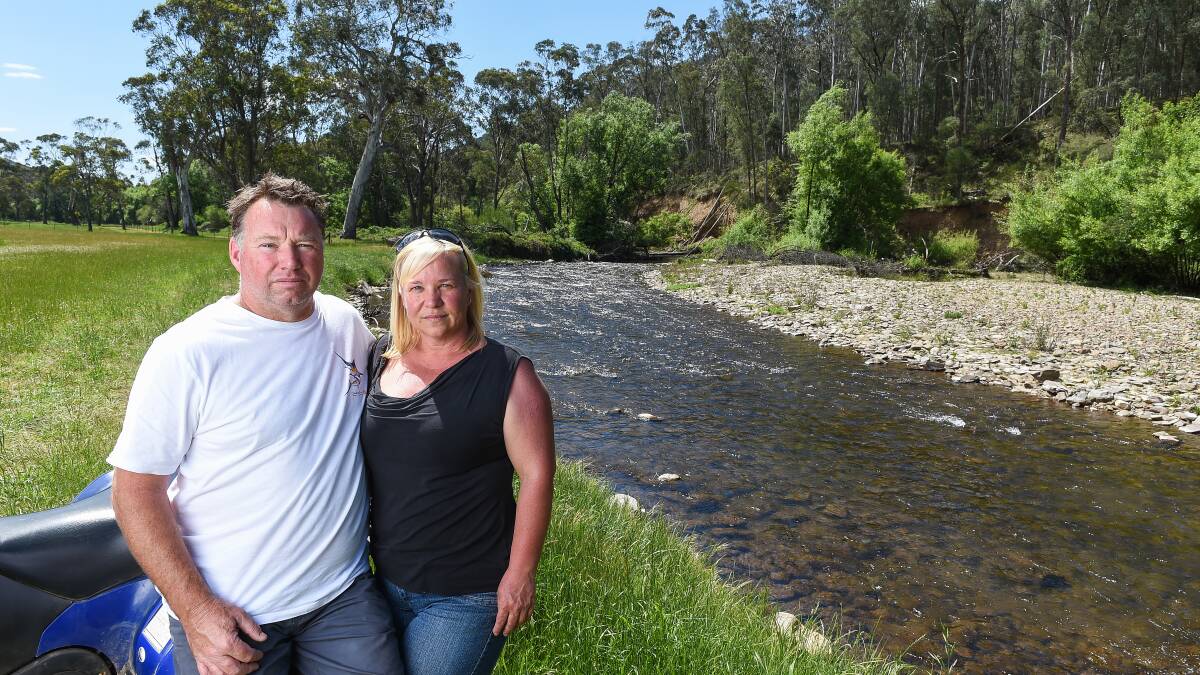 Fed up: Mark and Taola Baldwin on the edge of the Ovens River which adjoins their property at Smoko south of Bright. They are unhappy at the loss of land through the waterway flooding. Picture: MARK JESSER