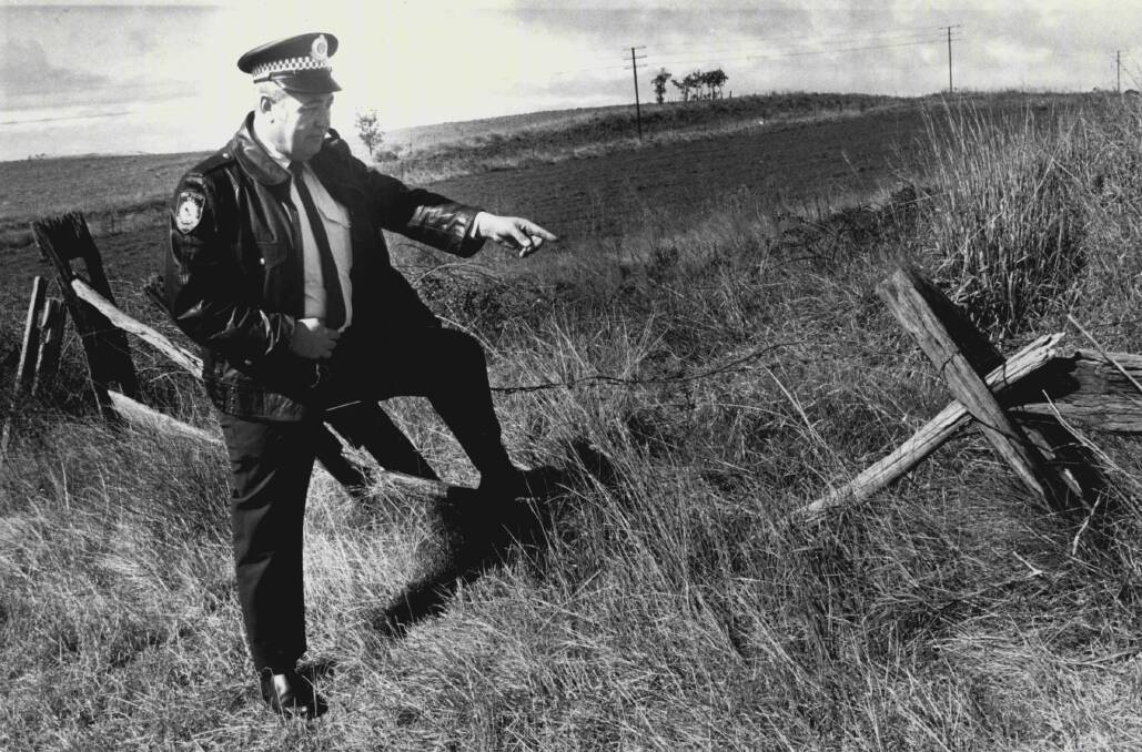 Flashback: A NSW rural crime officer points to a gap in the fence used by duffers during an incident in 1988. Former Victorian policeman and now politician Bill Tilley wants the model of farm policing north of the Murray River replicated in the Garden State.