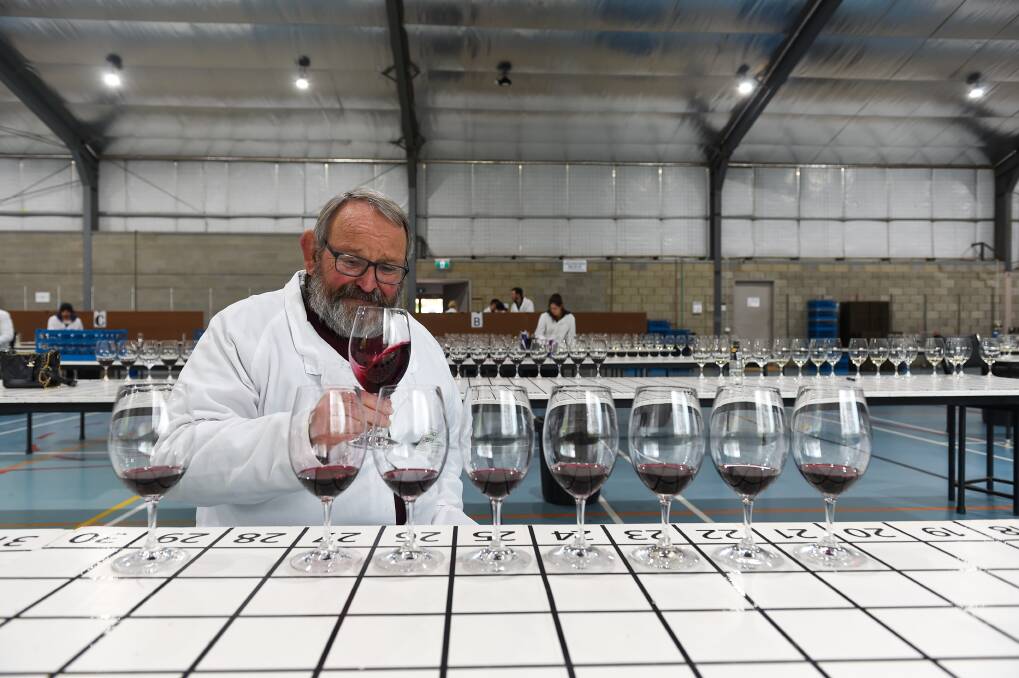 Getting reddy: Chris Pfeiffer assesses an entrant in last year's Rutherglen Wine Show. This year's event will proceed but with marked changes to cater for the effects of the coronavirus. Picture: MARK JESSER